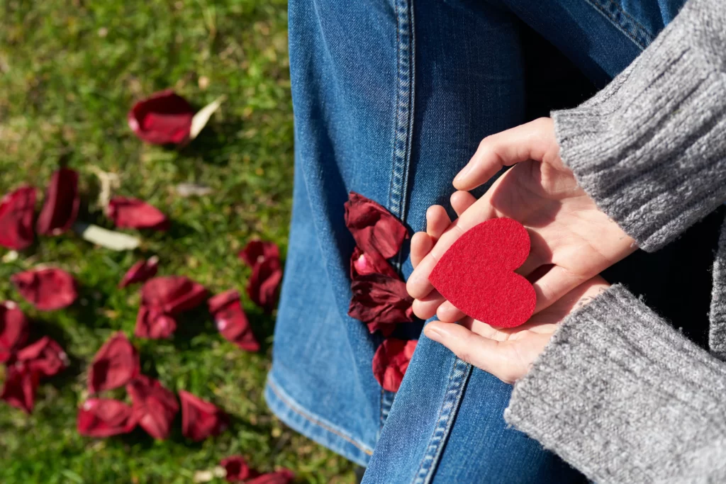 Ragazza che tiene nelle mani un cuore di carta ritagliato